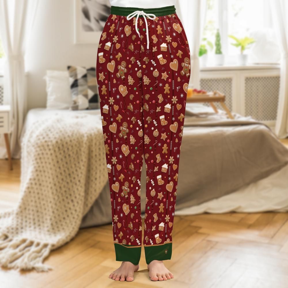 Cranberry-red satin pajama pants printed with iced gingerbread men, candy canes and snowflakes, forest-green cuffs with gold piping