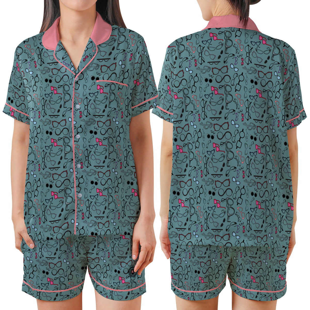 A women's pajama set shown on a model from the front and back, featuring a dark teal-green background with a black cartoon cat pattern and pink accents on the collar, trim, and small details.