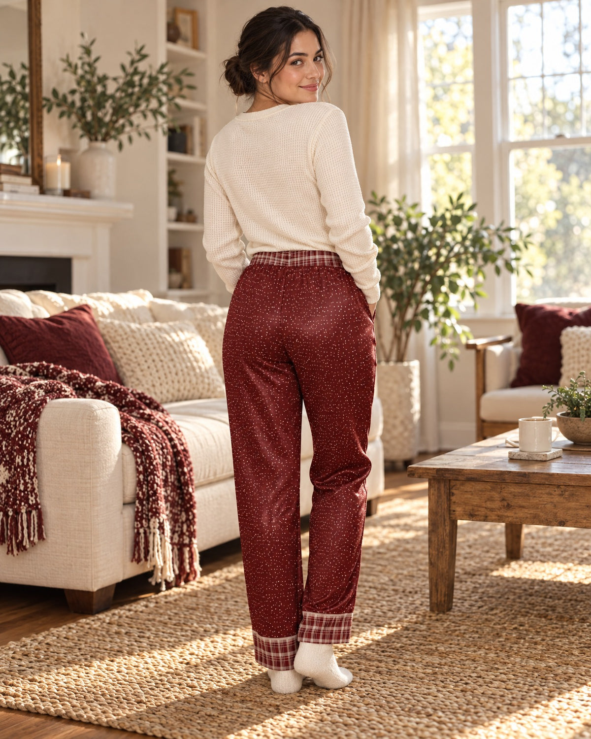 Back view of a woman in the Maroon & Cream satin pajama pants with a cream knit top, plaid waistband and cuffs