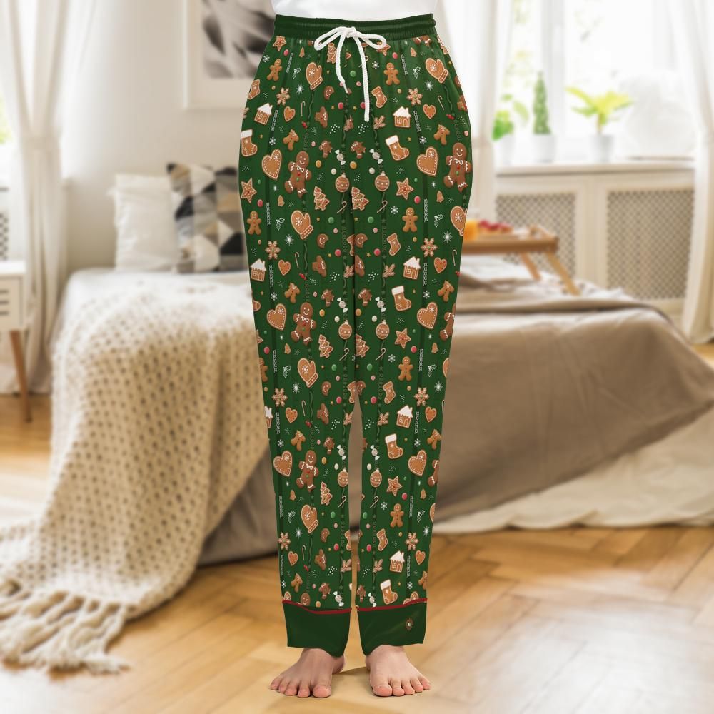 Pine-green satin pajama pants printed with iced gingerbread men, candy canes and snowflakes, tonal green cuffs with red piping