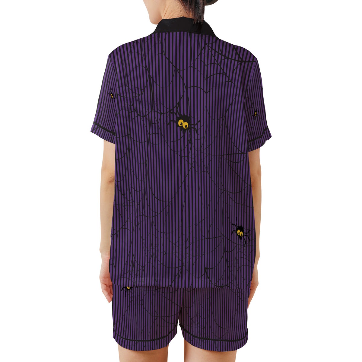 A model shown from the back wearing a matching two-piece Halloween pajama set. The set consists of a short-sleeve collared shirt and shorts, both in a dark purple color with thin black vertical stripes, black spiderwebs, and small black spiders with yellow eyes.